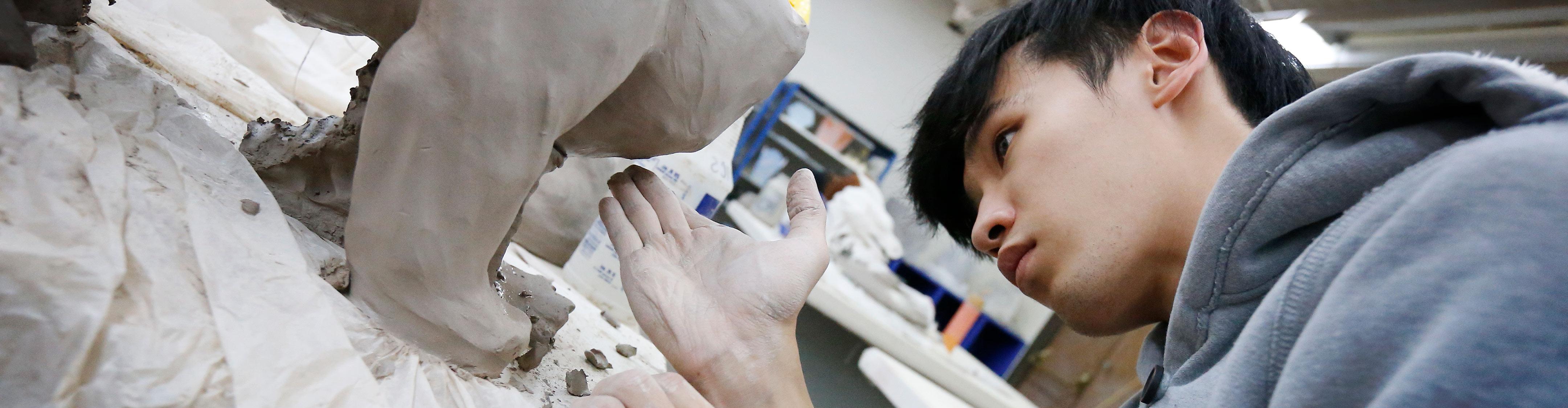 International 波胆平台 student making a sculpture